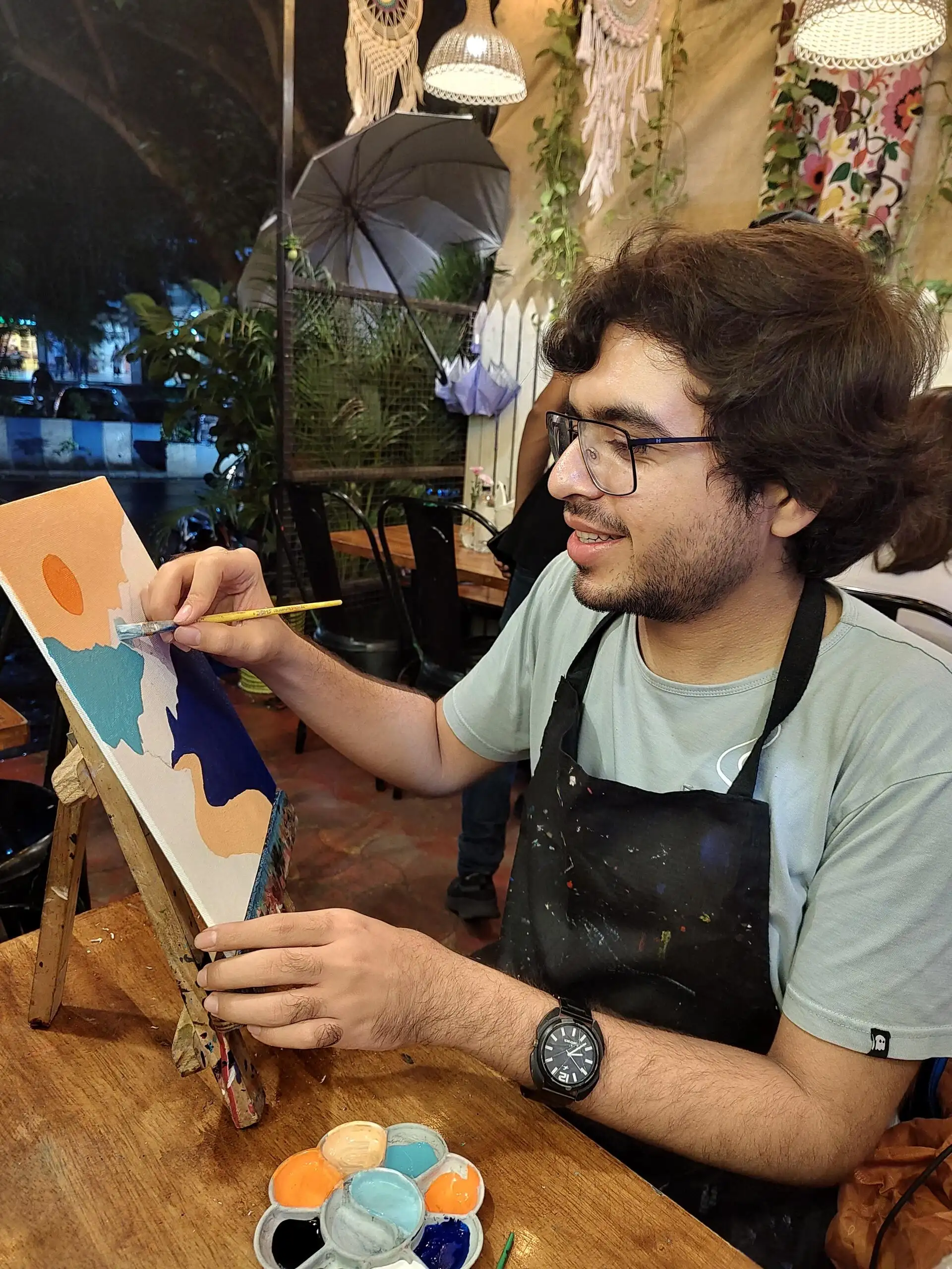Me painting a scene with mountains and a river