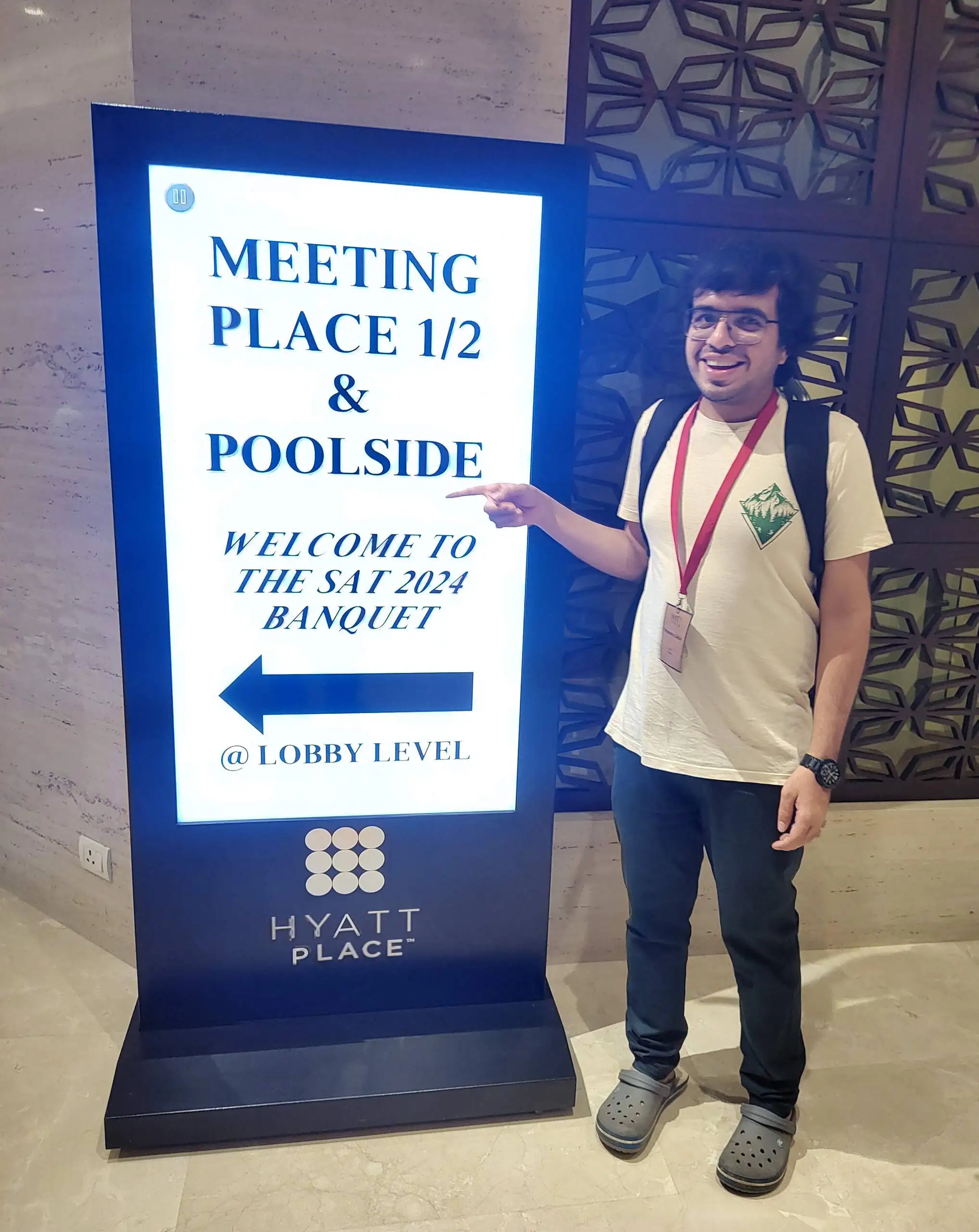 Me pointing at the banquet sign for SAT 2024