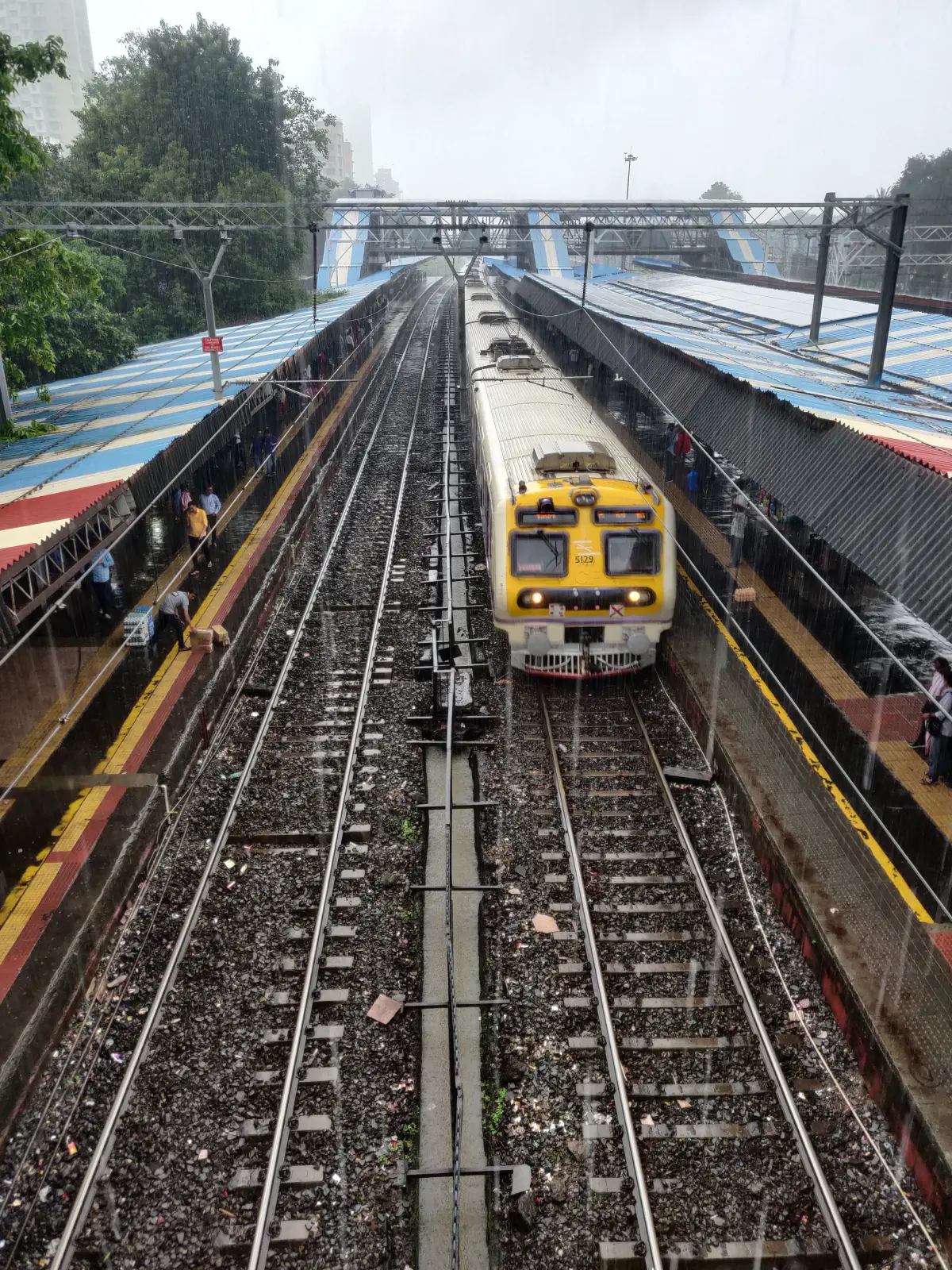 A train pulls into a station on a rainy day.