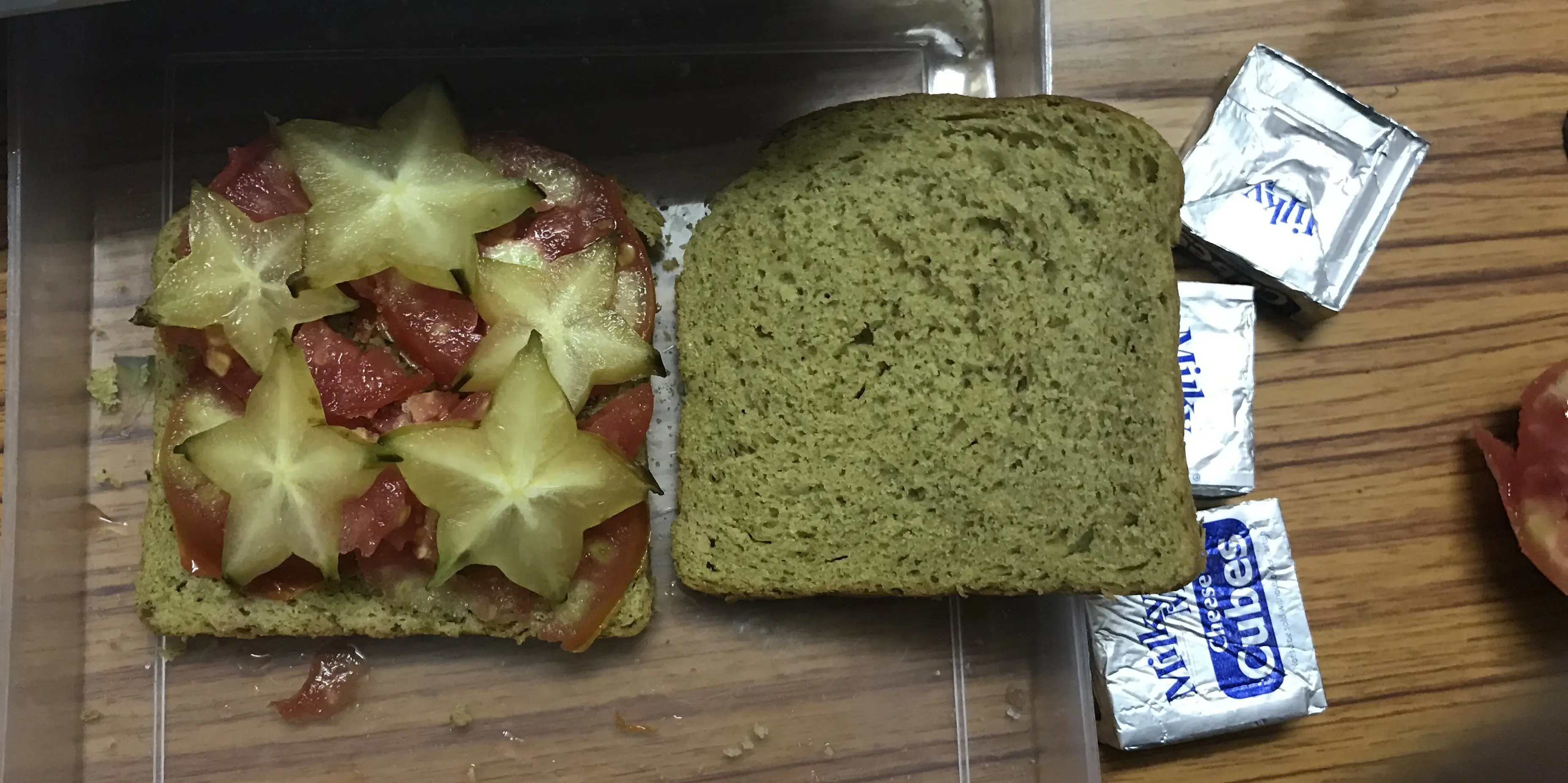 Tomato and starfruit slices placed on a slice of bread.
