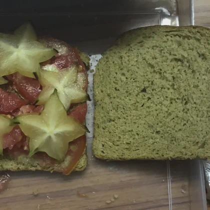 Tomato and starfruit slices placed on a slice of bread.