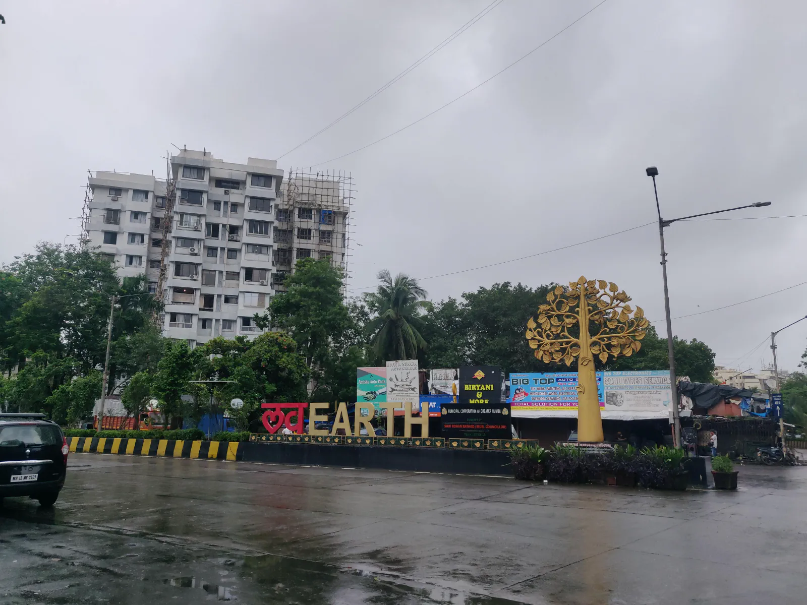 A "Love Earth" sign at a road intersection