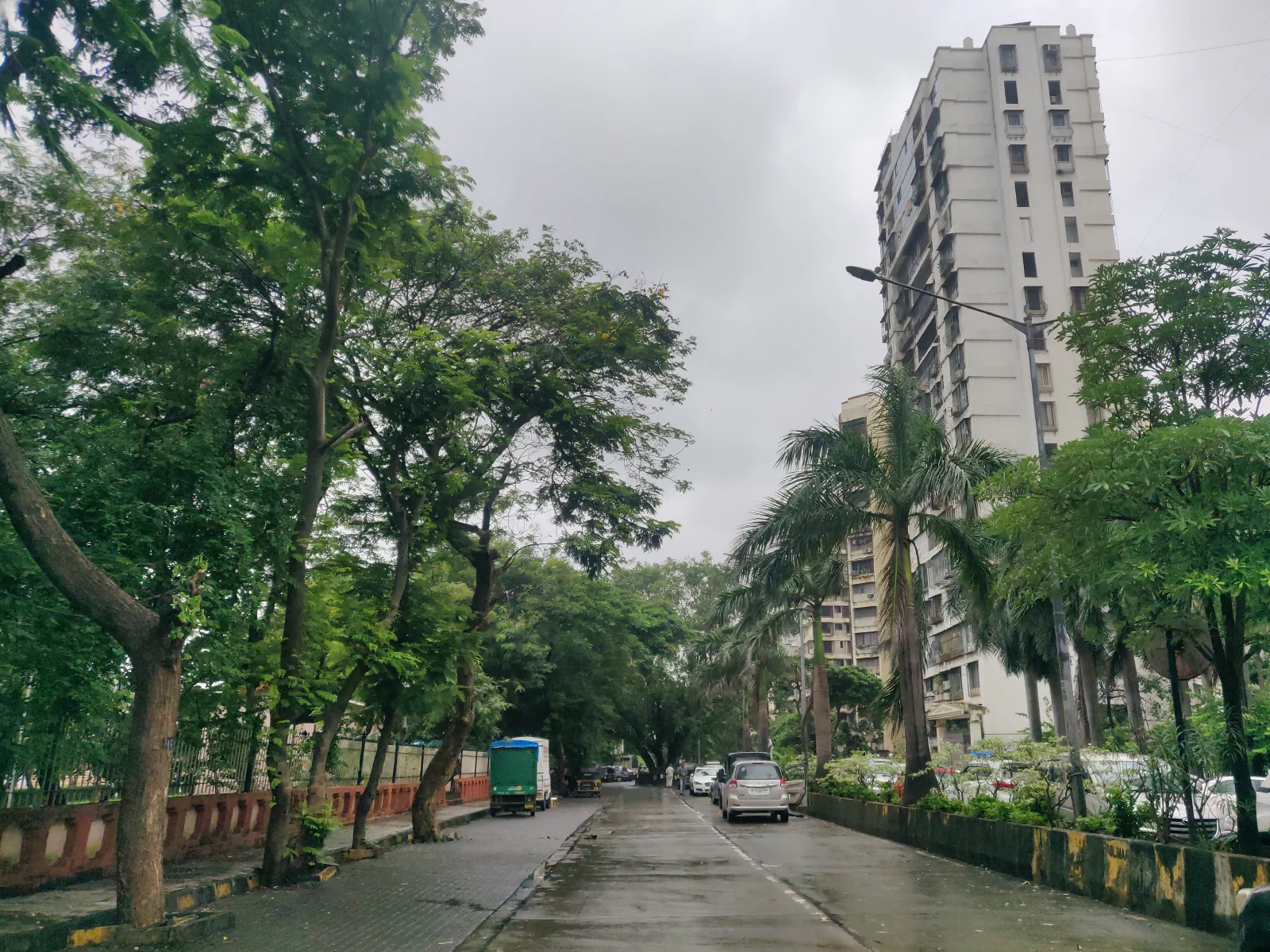 A deserted road with cars parked in the middle. 