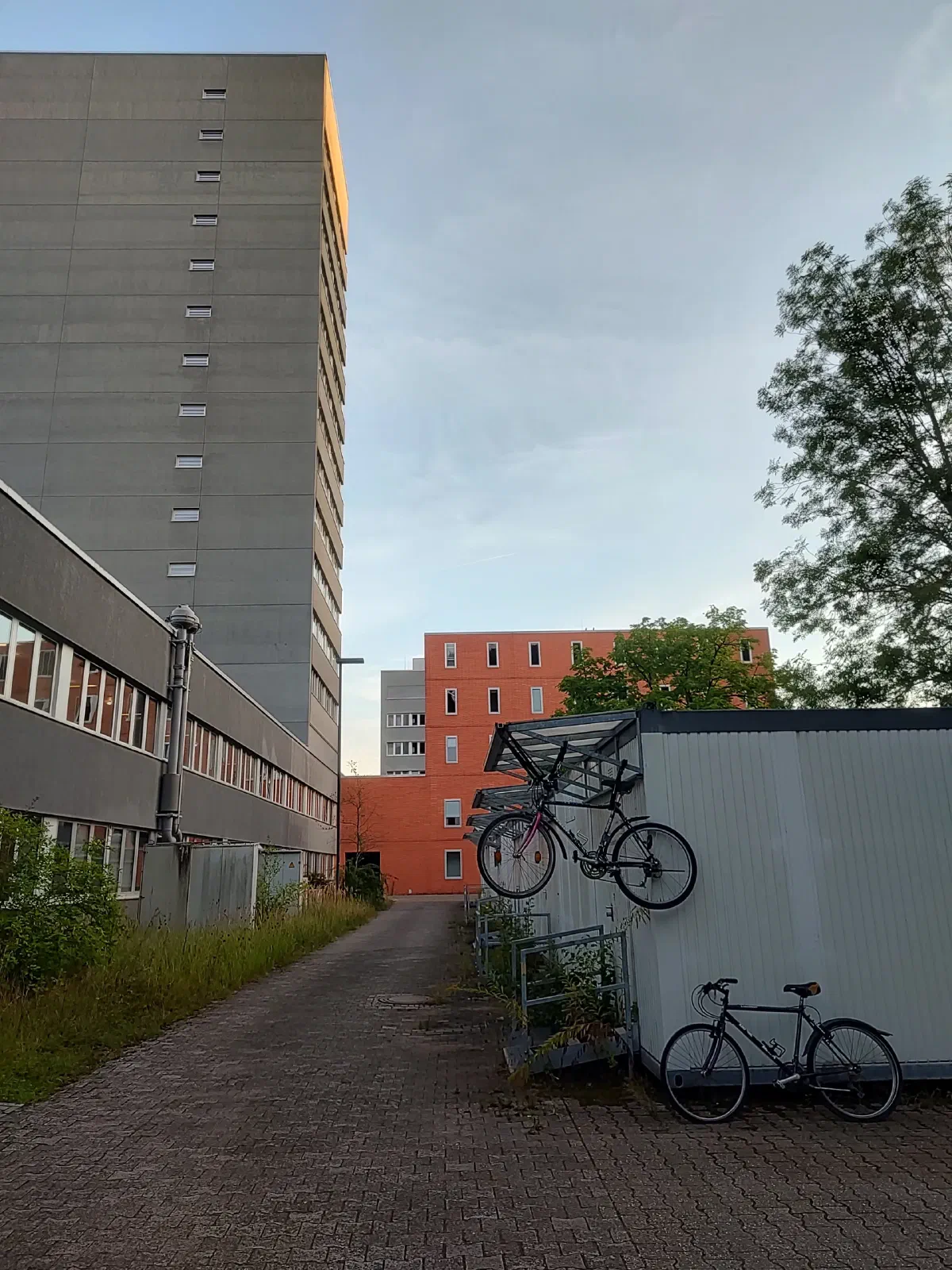 Two bicycles: one on the ground and one up above.