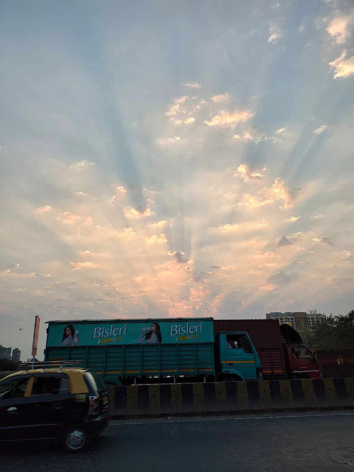 A Bisleri truck passes by the sunburst.
