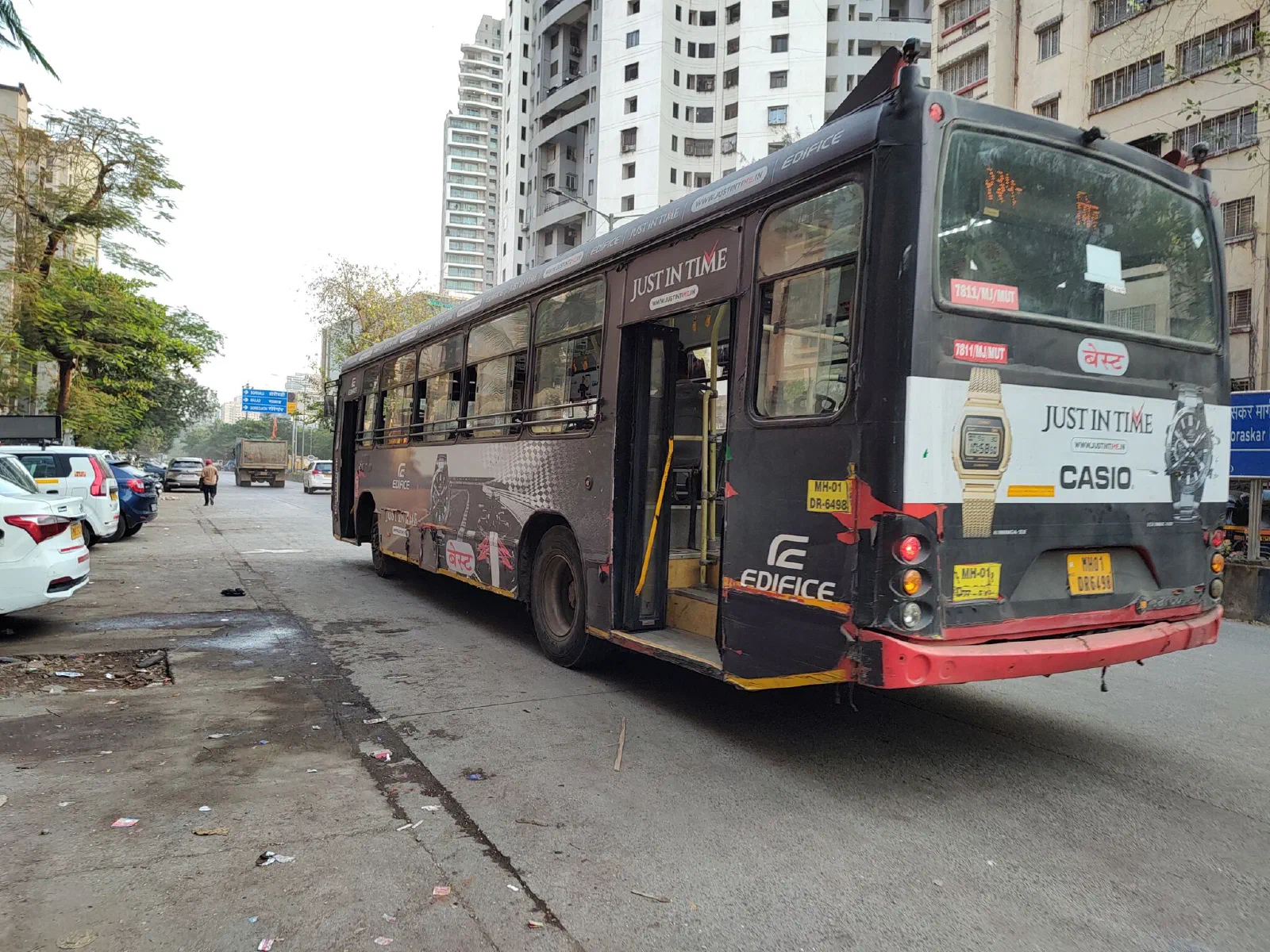 A BEST Bus plastered in watch advertisements.
